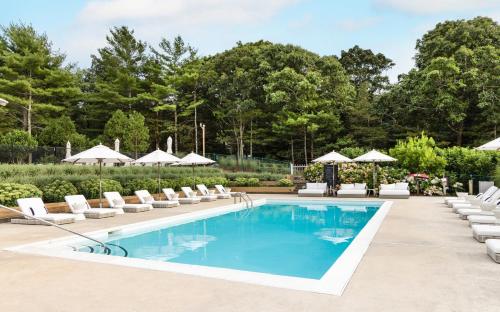 uma piscina com espreguiçadeiras e guarda-sóis em EHP Resort & Marina em East Hampton