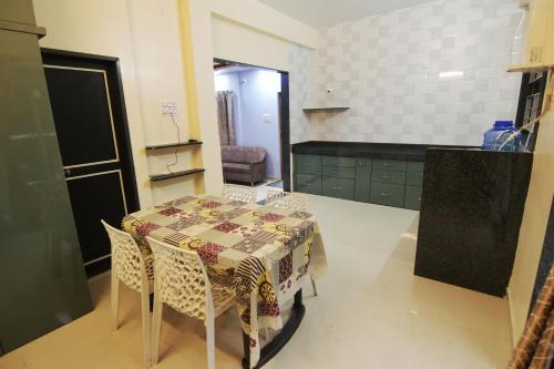 cocina con mesa y sillas en una habitación en Picaddle Serviced Apartment en Belgaum