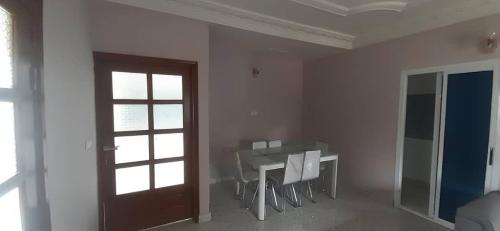 a white room with a table and a door at KDN Sweet Home Meublés in Yaoundé