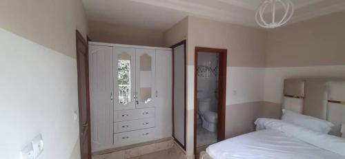 a bedroom with a bed and a large mirror at KDN Sweet Home Meublés in Yaoundé
