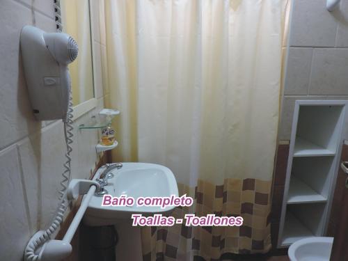 a bathroom with a shower with a phone and a sink at Cabañas Costa Azul in Sauce Viejo