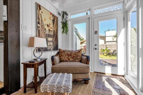a living room with a chair and a table at Sneaky Tiki: Heated Saltwater Pool+5 min to beach in Largo