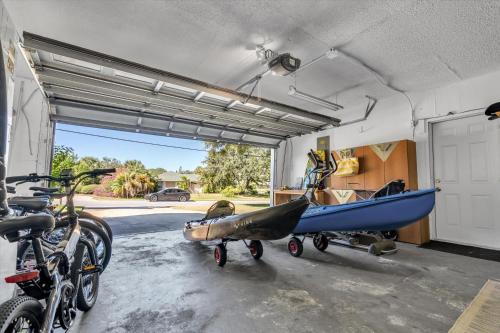 a garage with a boat on a cart in it at Sneaky Tiki: Heated Saltwater Pool+5 min to beach in Largo