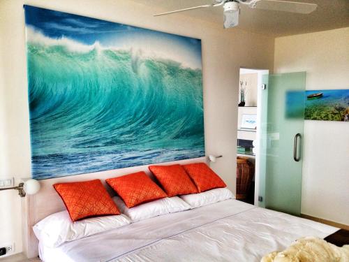 een slaapkamer met een schilderij boven een bed met oranje kussens bij Stunning 2 bedroom View condo in Maho in Lowlands