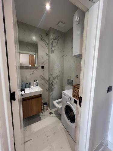 a bathroom with a washing machine and a sink at Kabaseo Spa in Becici