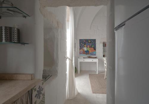 un couloir blanc avec une table blanche et une chambre dans l'établissement Casalice - Second Home, à Ostuni