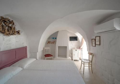 - une chambre blanche avec un lit et une chaise dans l'établissement Casalice - Second Home, à Ostuni