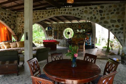 een eetkamer met een tafel met een vaas met bloemen erop bij Casa Cangrejal B&B Hotel in La Ceiba