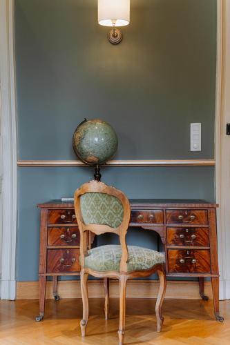 a chair sitting in front of a desk with a lamp at Chateau de Bézyl in Sixt-sur-Aff