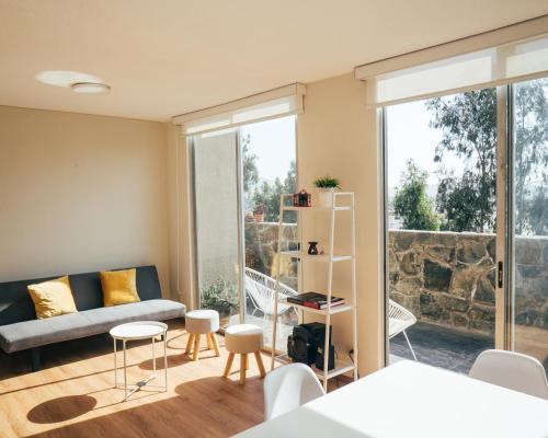 Acogedor departamento con amplia terraza في ليما: غرفة معيشة مع أريكة وطاولة