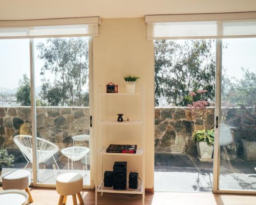 una sala de estar con puertas correderas de cristal y una estantería de libros. en Acogedor departamento con amplia terraza en Lima