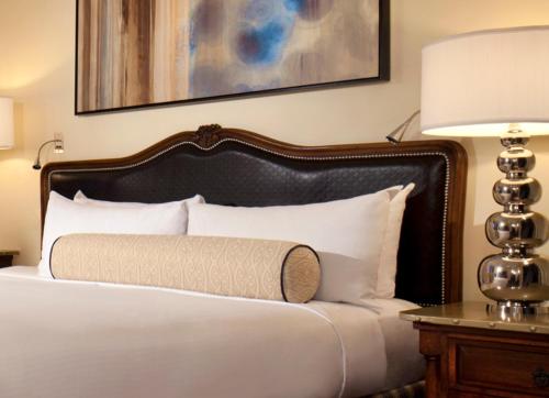 a bed with a black headboard and white pillows at Green Valley Ranch Resort Spa Casino in Las Vegas