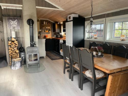 a kitchen and dining room with a table and a stove at Hytte med Anneks og fantastisk utsikt på Ljøsheim in Mesnali