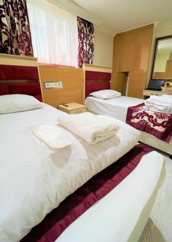 Dos camas en una habitación de hotel con toallas. en Viva Hotel Laleli, en Estambul
