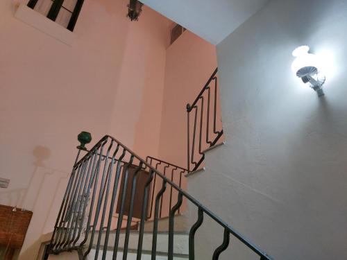a staircase in a building with a light on the wall at Antica Via delle Aie in Ruffano