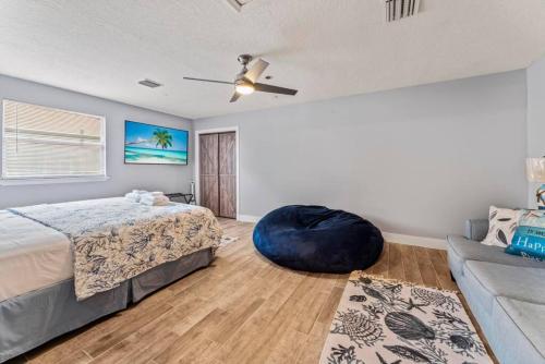 a bedroom with a bed and a blue ottoman at Saltwater Oasis - Large Pool in Jacksonville Beach