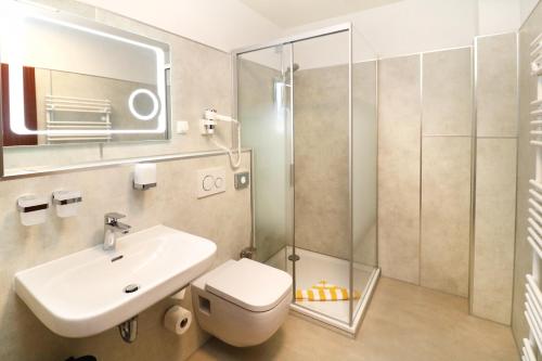 a bathroom with a toilet and a sink and a shower at Hotel Pension Kirschstein in Wolgast