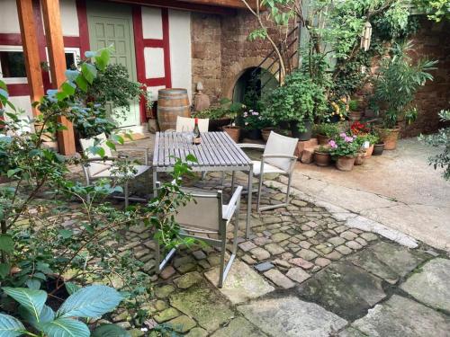a patio with a table and chairs and plants at Ferienwohnung Unterm Schloß in Neustadt an der Weinstraße