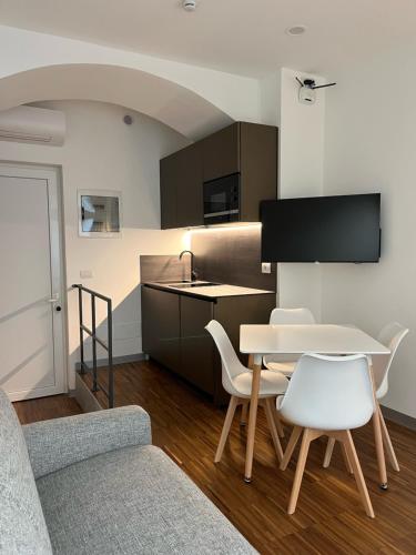 ein Wohnzimmer mit einem Tisch und Stühlen sowie eine Küche in der Unterkunft MiAp ORTI 31 in Mailand