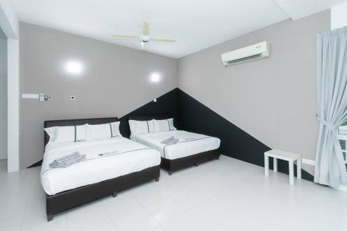 a bedroom with two beds and a window at Beach side spacious 5BR 20pax pool house in Batu Ferringhi