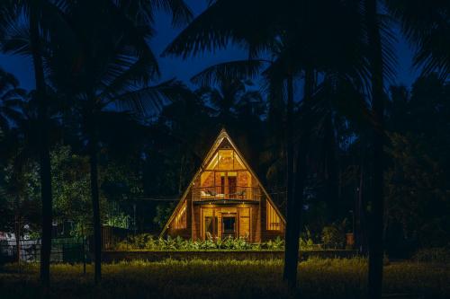 a house in the middle of a forest at night at Bimal's Casa de Papel in Kadikkād