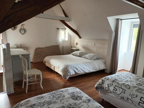 1 Schlafzimmer mit 2 Betten, einem Tisch und einem Stuhl in der Unterkunft Au bout du monde 1 in Les Hermites