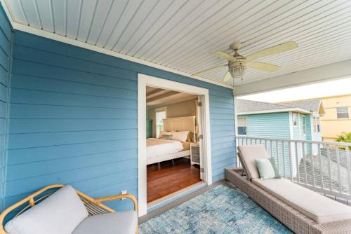 Casa azul con ventilador de techo y balcón con cama. en Ocean views, Elevator, Game Room, Two balconies, en Jacksonville Beach