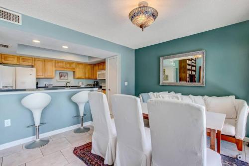 a dining room with white chairs and a kitchen at Golf Front - Sawgrass Gate Community in Ponte Vedra Beach