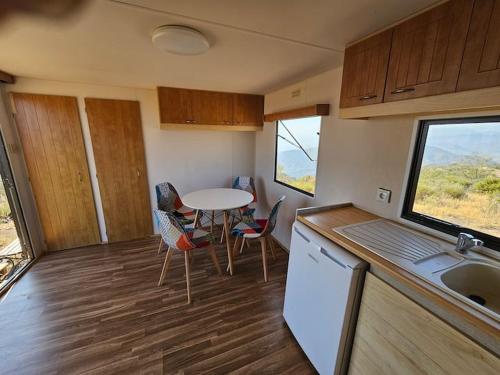 eine kleine Küche mit einem Tisch und Stühlen in einem Wohnwagen in der Unterkunft Minicasa con vistas al mar in Casabermeja