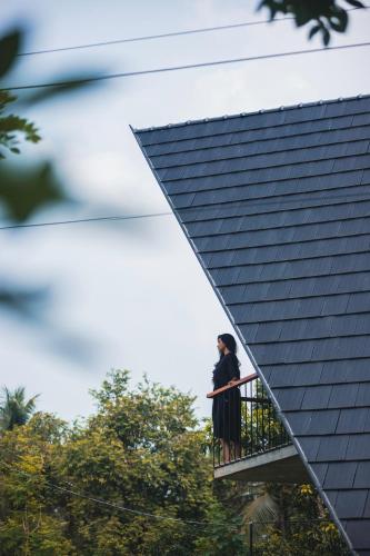 a couple standing on a balcony next to a building at Bimal's Casa de Papel in Kadikkād
