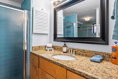 a bathroom with a sink and a mirror and a shower at Sandpiper Oceanfront 5C in Jacksonville Beach