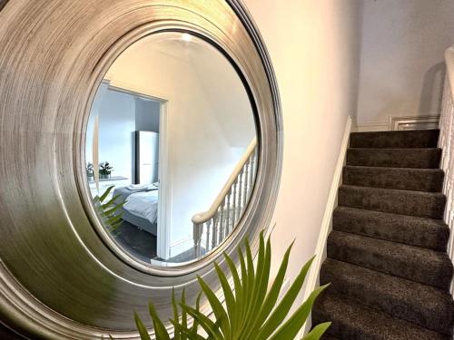 okrągłe lustro na ścianie obok schodów w obiekcie Middleton House by Blue Skies Stays w mieście Hartlepool