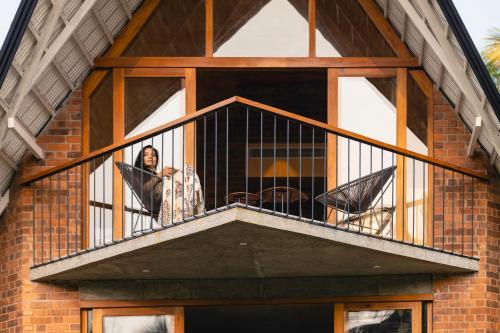 a woman looking out of a window on a balcony at Bimal's Casa de Papel in Kadikkād