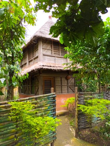 an old house with a fence in front of it at Ferme Yaka YALE in Palimé