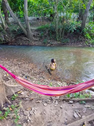 a woman sitting in a hammock in a body of water at Ferme Yaka YALE in Palimé