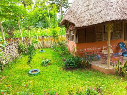 a small hut with a grass roof in a yard at Ferme Yaka YALE in Palimé