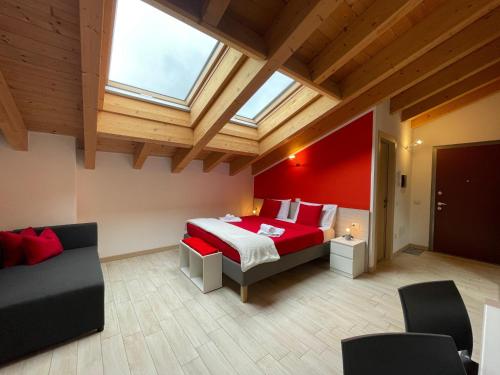 1 dormitorio con cama roja y tragaluz en Valtellinahome, en Villa di Tirano
