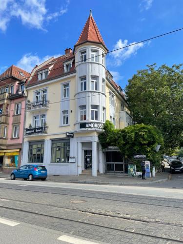 ein weißes Gebäude mit einem Turm auf einer Straße in der Unterkunft AUERSTEIN-Hotels auerstein & auerstein-mono in Heidelberg