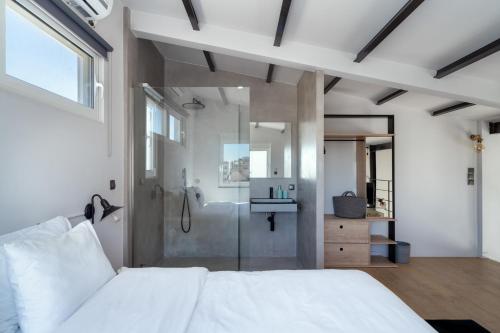 ein Schlafzimmer mit einem weißen Bett und einer Dusche in der Unterkunft One Shade of Grey Loft with Private Terrace in Athen