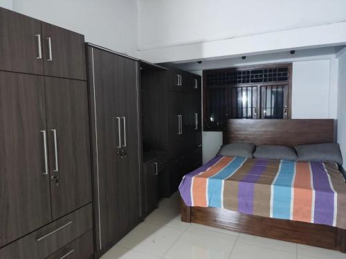a bedroom with a bed and some wooden cabinets at Coco Bay in Beruwala