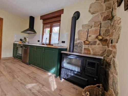 a kitchen with a stone wall and a stove at Los Kukos Casa Rural in Riaño