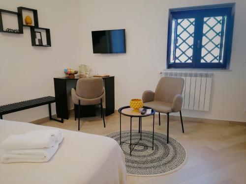 1 Schlafzimmer mit einem Bett, 2 Stühlen und einem Tisch in der Unterkunft I Canti Comfort Rooms in Palermo