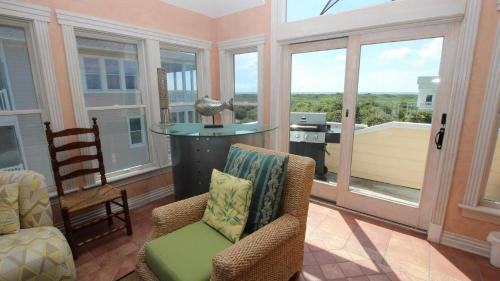 a screened in porch with chairs and a table and windows at OCEANFRONT, Ocean Views, Pool, Hot Tub, PI202, Turtle Key in Sanderling