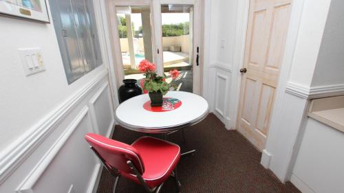 a small table with red chairs and a vase with flowers at OCEANFRONT, Ocean Views, Pool, Hot Tub, PI202, Turtle Key in Sanderling