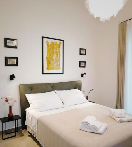 a white bedroom with a bed with towels on it at I Canti Comfort Rooms in Palermo