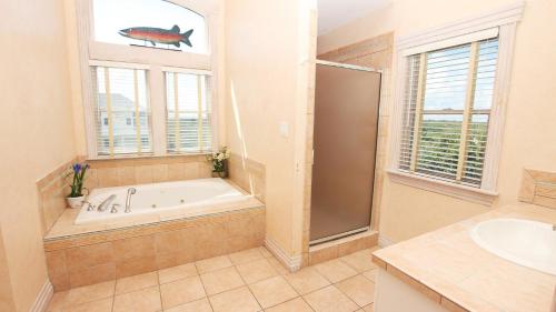 a bathroom with a tub and a sink and a window at OCEANFRONT, Ocean Views, Pool, Hot Tub, PI202, Turtle Key in Sanderling