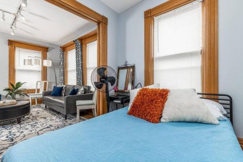 a bedroom with a blue bed and a living room at The Dubuque House - Historic Downtown Location! in Dubuque
