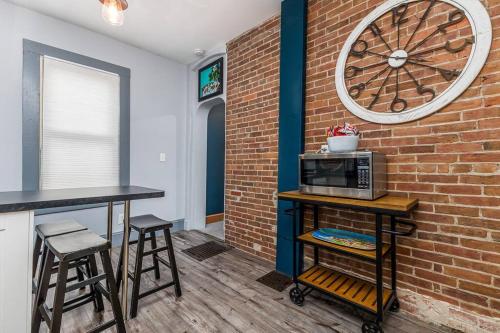 a kitchen with a brick wall and a microwave on a table at The Dubuque House - Historic Downtown Location! in Dubuque