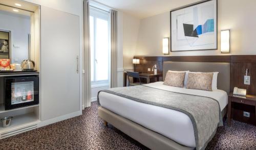 a hotel room with a bed and a desk at Elysées Ceramic in Paris