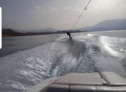 a man water skiing on a boat in the water at Le Figuier du Lac Bin elouidane in Bine el Ouidane